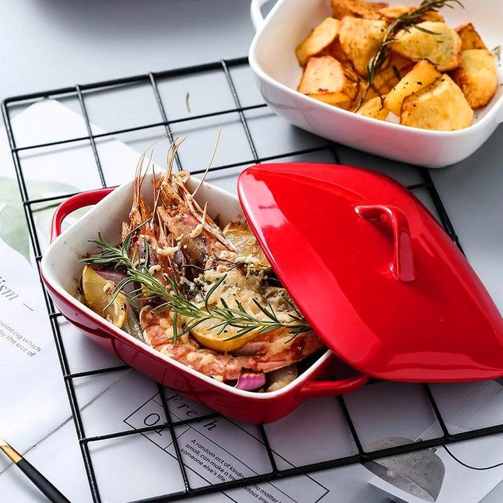 a red casserole dish with shrimp and potatoes in it on a wire rack