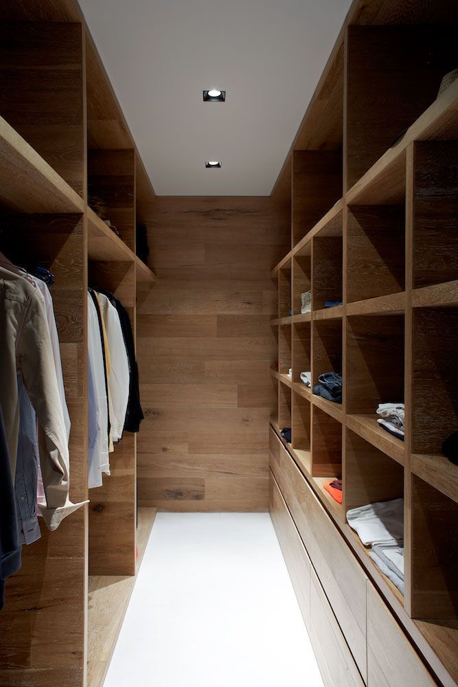 an image of a walk in closet with lots of shelves and clothes on the shelves