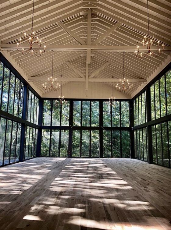 an empty room with large windows and wooden floors