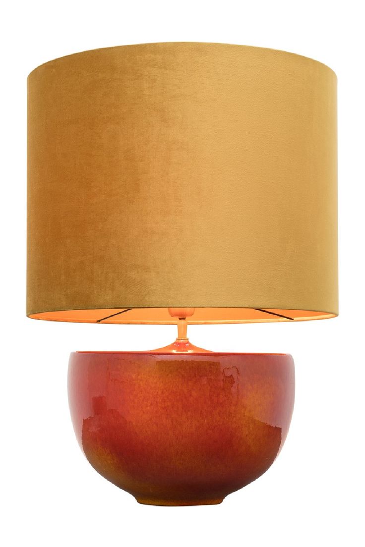 a red lamp with a gold shade on it's base and a white background