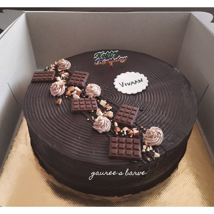 a chocolate cake with white frosting and toppings in a box