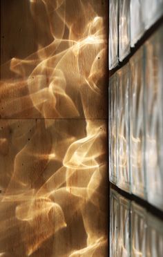 the wall is made up of glass blocks with sunlight streaming through them and reflecting on it