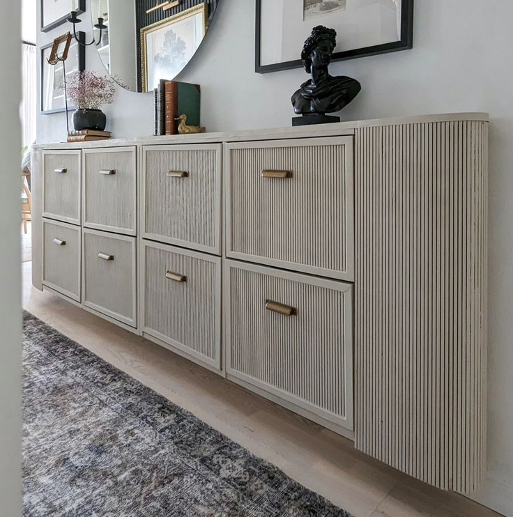 a dresser with drawers and pictures on the wall