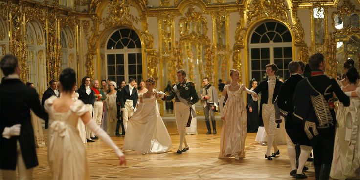 a group of people dressed in formal wear walking around an ornately decorated room with gold and white walls