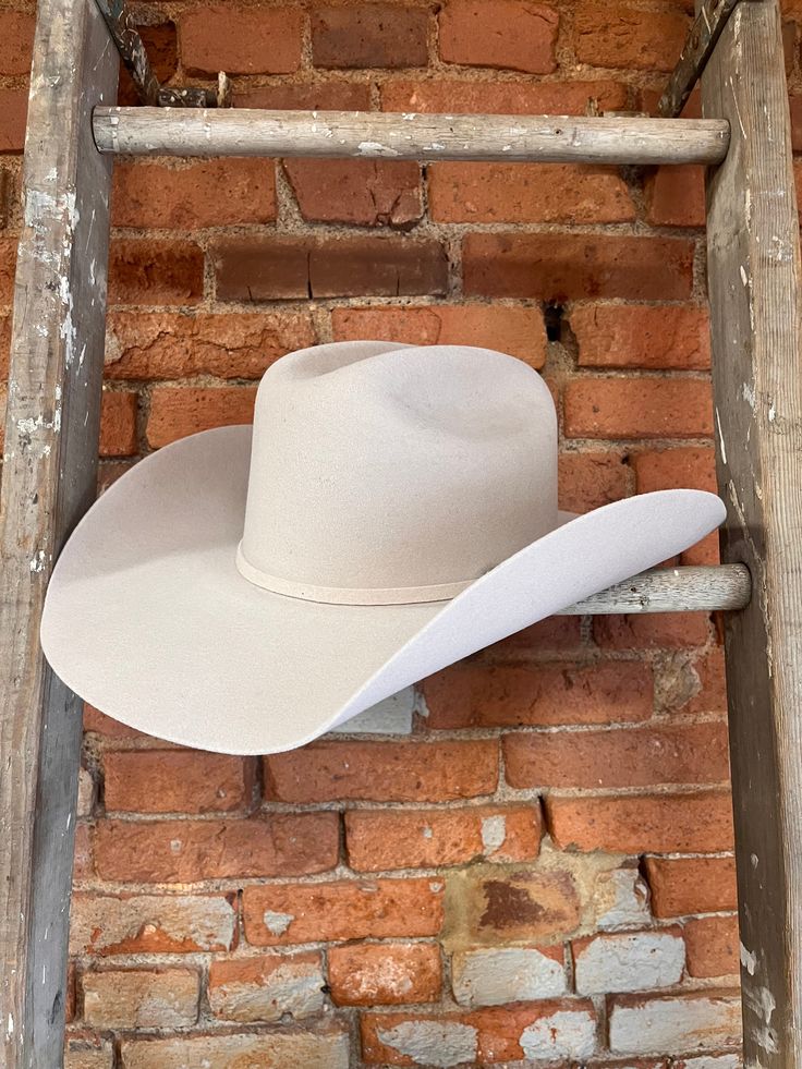 Looking for a cowboy hat that's as stylish as it is functional? Look no further than the Serratelli Mesa Cowboy Hat! Serratelli Hats are a statement piece rooted in true western heritage. With over 100 years experience, Serratelli knows how to make a cowboy hat look and feel great. Crafted from pure wool construction, this cowboy hat is designed to withstand even the toughest conditions, while keeping you looking sharp and polished. The classic Cattleman crease adds a traditional touch, while the matching hat band with a three-piece silver-tone self band buckle set elevates the hat's overall aesthetic.Sporting a shovel front brim, this hat cuts a distinctive silhouette that's sure to turn heads wherever you go. The 4 1/4" brim offers ample protection from the sun, while the 4 3/16" crown p Cattleman Cowboy Hat, Hats Women Fashion, Cowboy Hat Shapes, Make A Cowboy Hat, Cowboy Hat Outfit, Customized Hats, Parker Mccollum, Cowgirl Hats Western, Ranch Wife