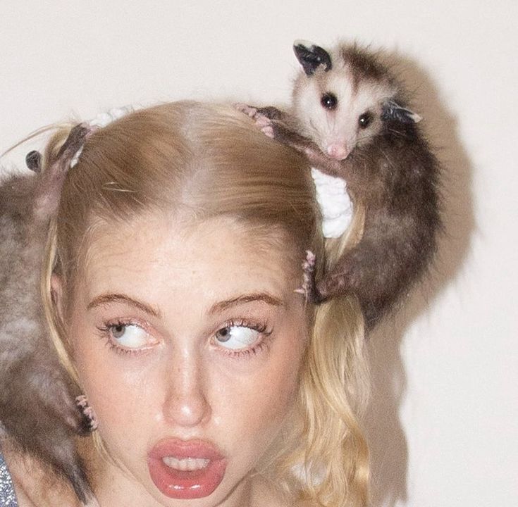 a woman with two possles on her head and another animal sitting on top of her head