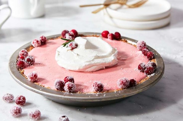 a dessert with whipped cream and cranberries on a plate