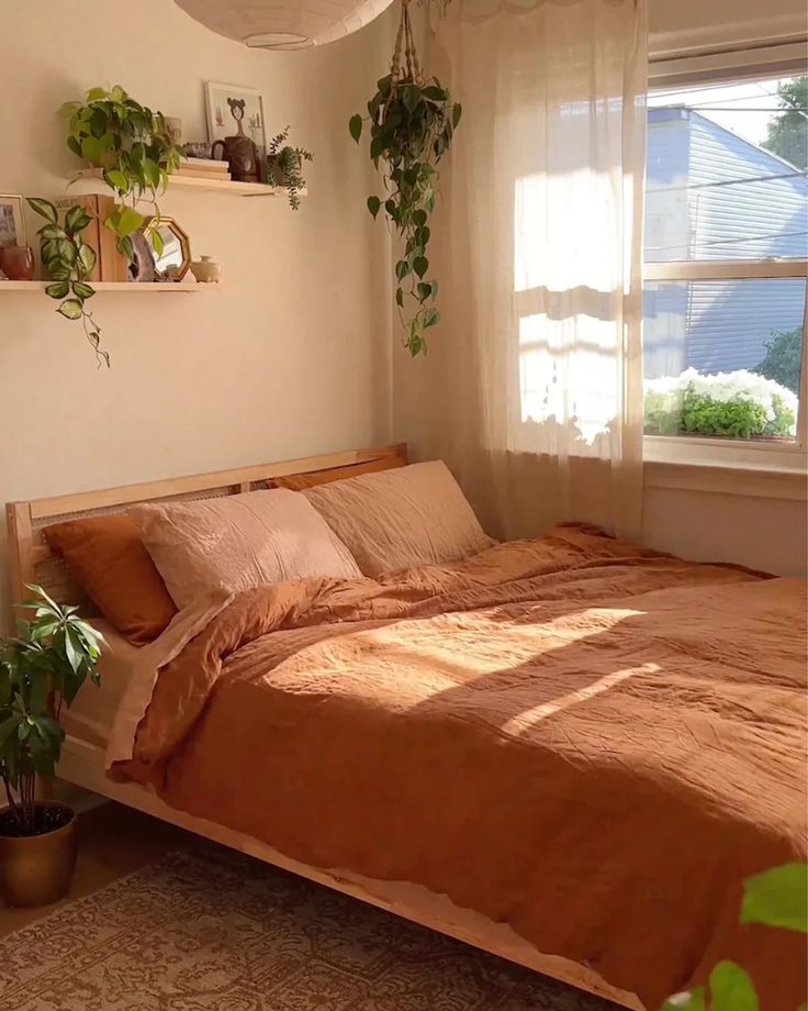 a bed sitting under a window next to a potted plant