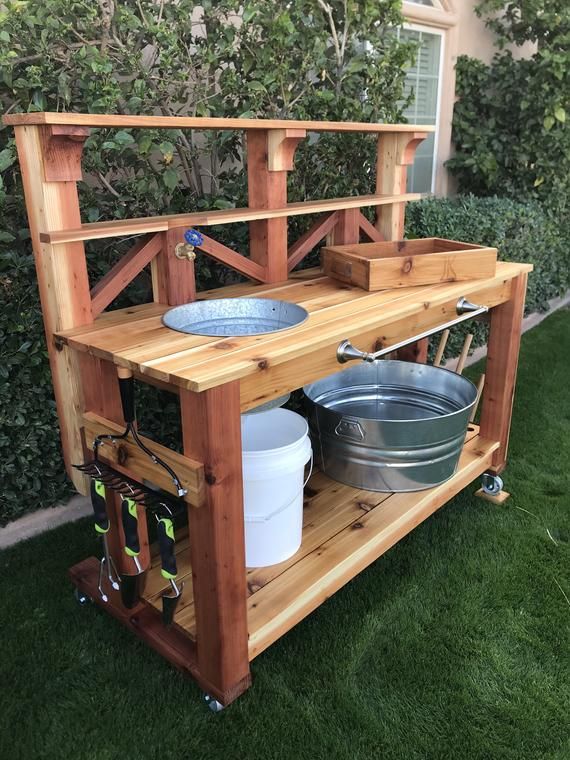 a potting station made out of pallets and wood with two buckets on it