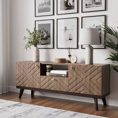 a living room with pictures on the wall and a sideboard in front of it