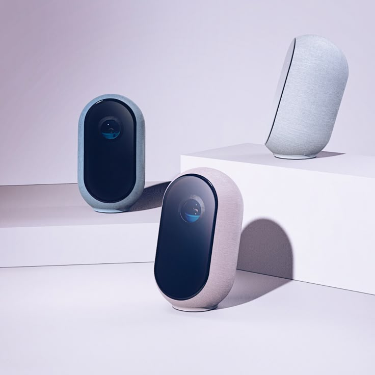 two speakers sitting on top of each other near one another in front of a white wall