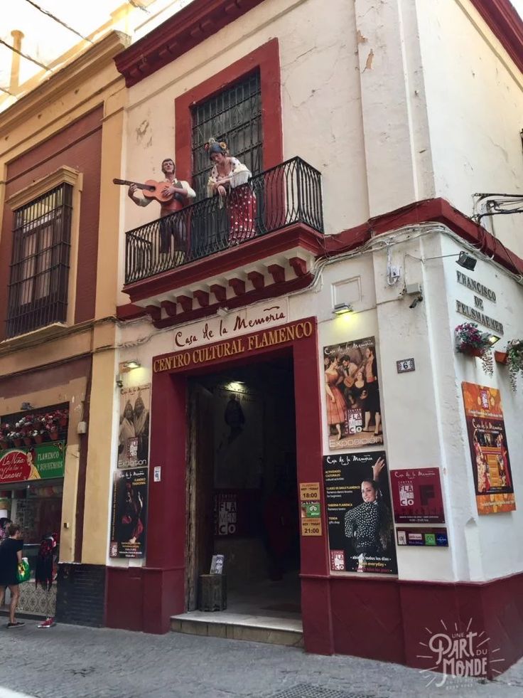 people are standing on the balconies of an old building that has been painted red and white