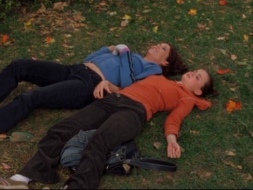 two people are laying on the grass together