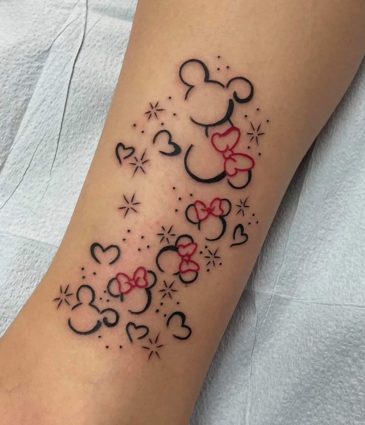 a tattoo on the arm of a woman with mickey mouse ears and stars around it