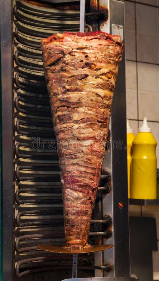 a large piece of meat is being cooked on the grill