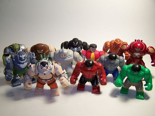 a group of toy action figures sitting next to each other on a white table top