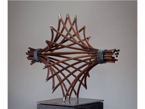 a sculpture made out of metal rods on top of a wooden block