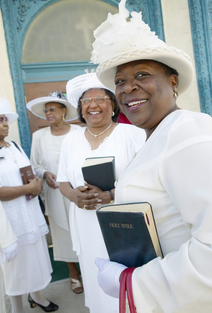 several women in white dresses and hats holding books