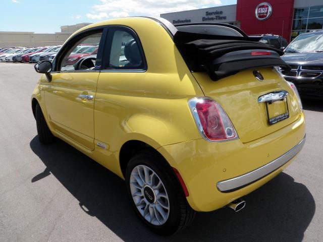 a small yellow car parked in a parking lot