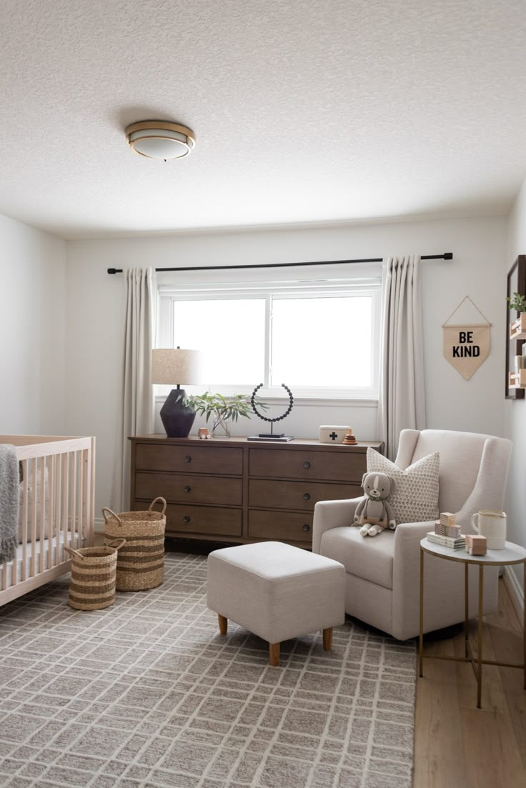 a baby's room with a crib, chair and dresser