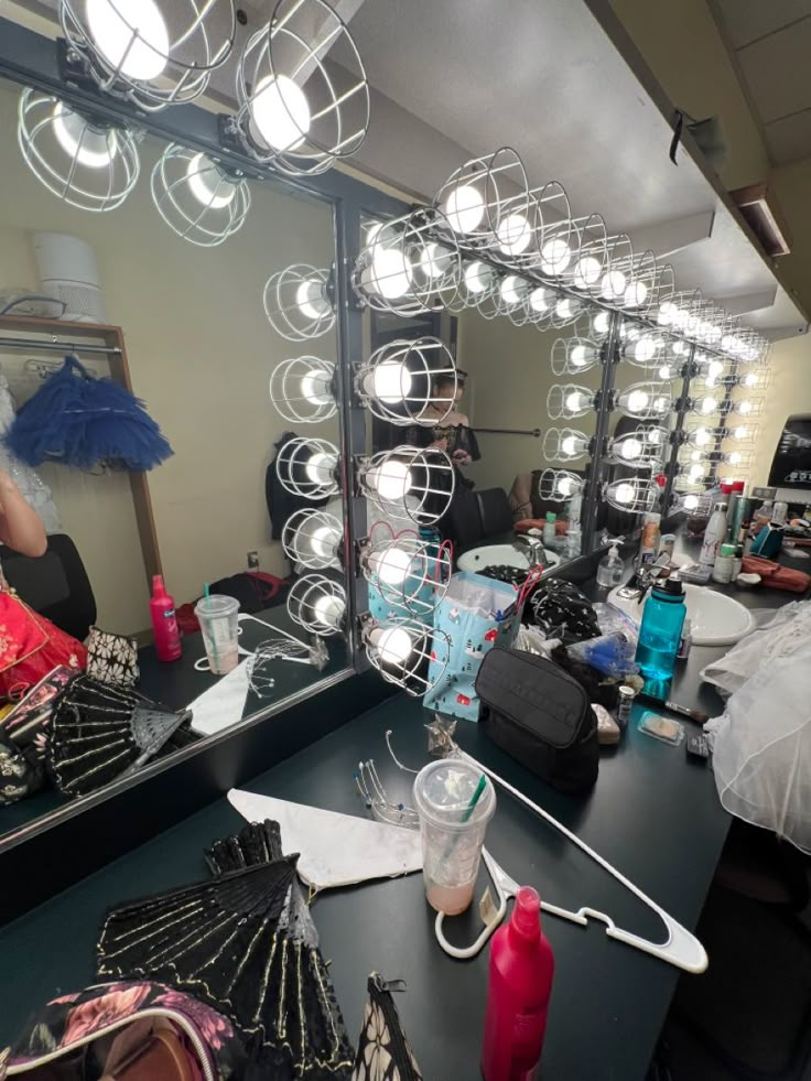 a woman standing in front of a mirror with lots of hair and makeup products on it