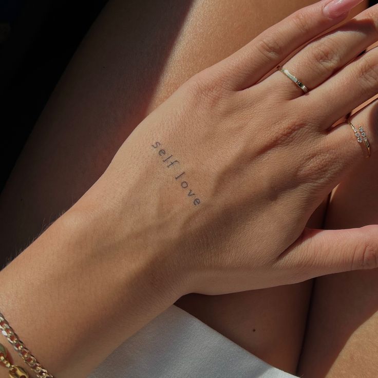 a close up of a person's hand with tattoos on it