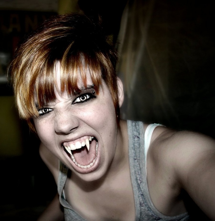 a young woman with her mouth open and teeth wide open, posing for the camera