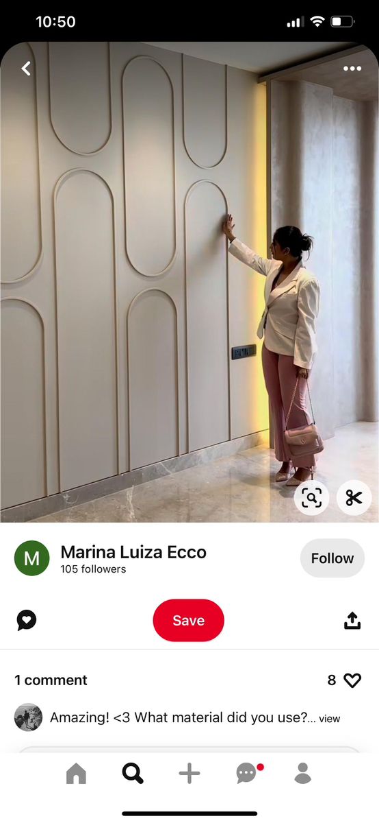 a woman standing in front of a white wall next to a door with the words marina luzza eco written on it