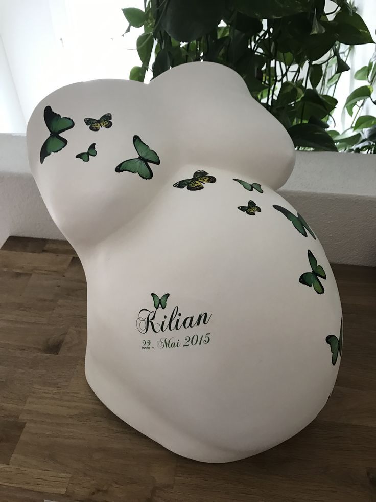 a white bear with green butterflies on it's back and name written on the side