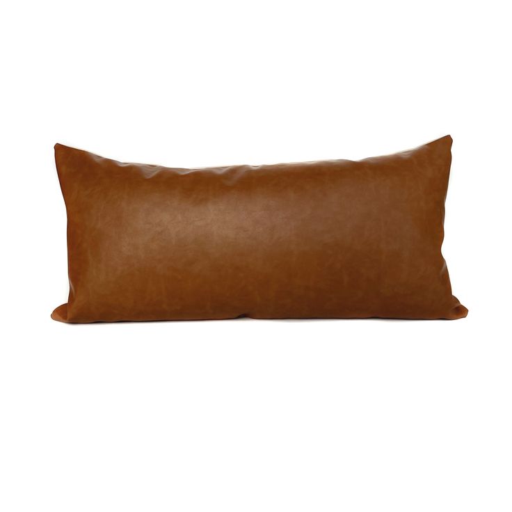 a brown leather pillow on a white background