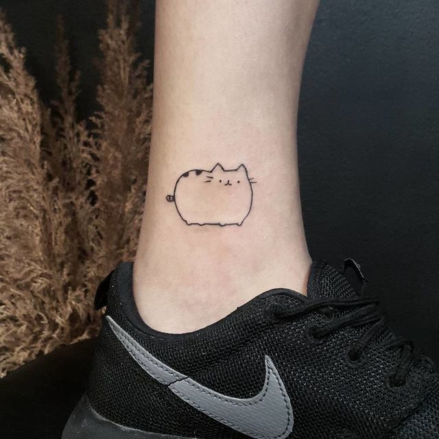 a small cat tattoo on the ankle