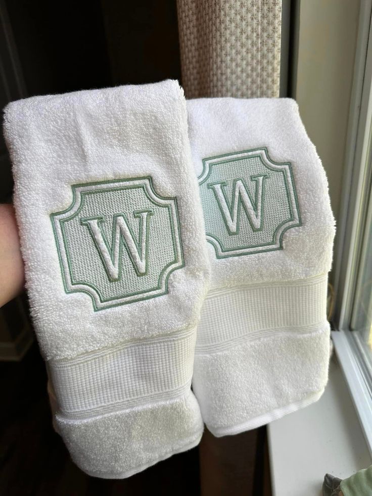 two white towels with the letter w on them