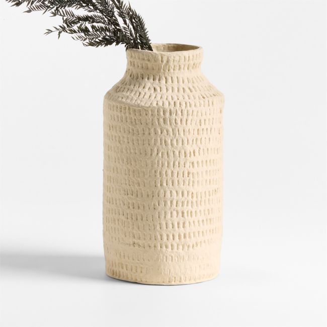 a vase with a plant sticking out of it's side, against a white background