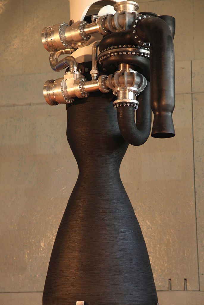 a black vase with metal pipes sticking out of it