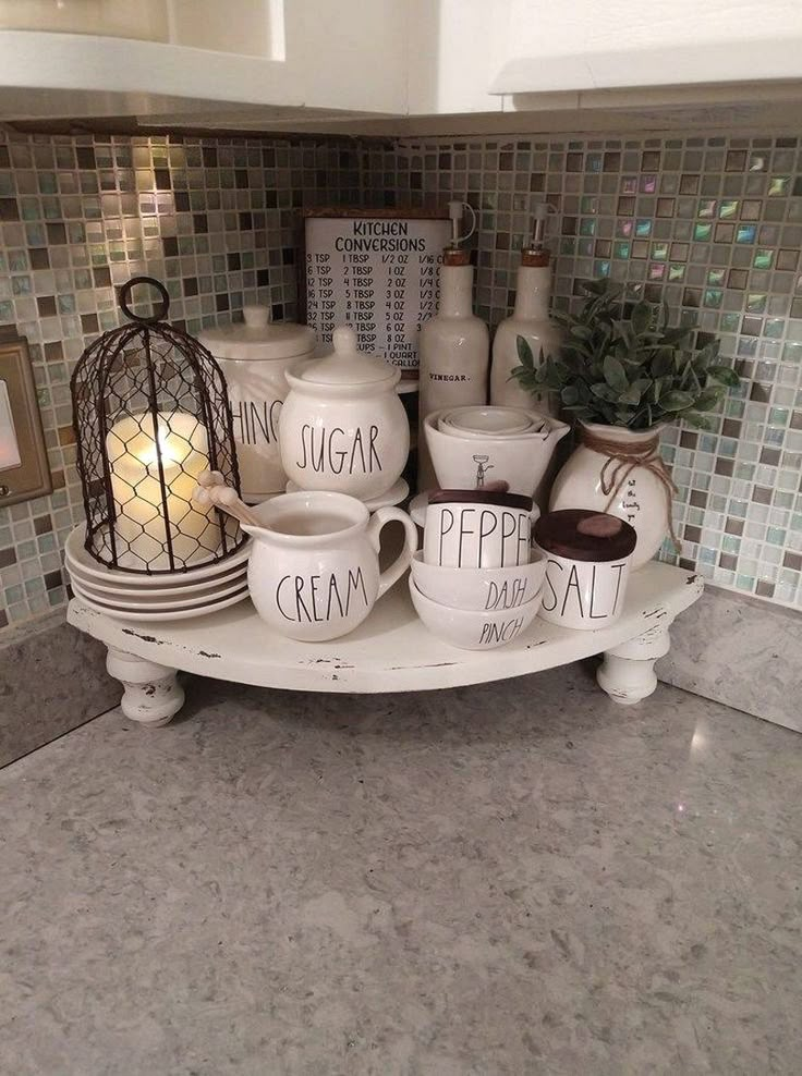 a kitchen counter topped with white dishes and cups