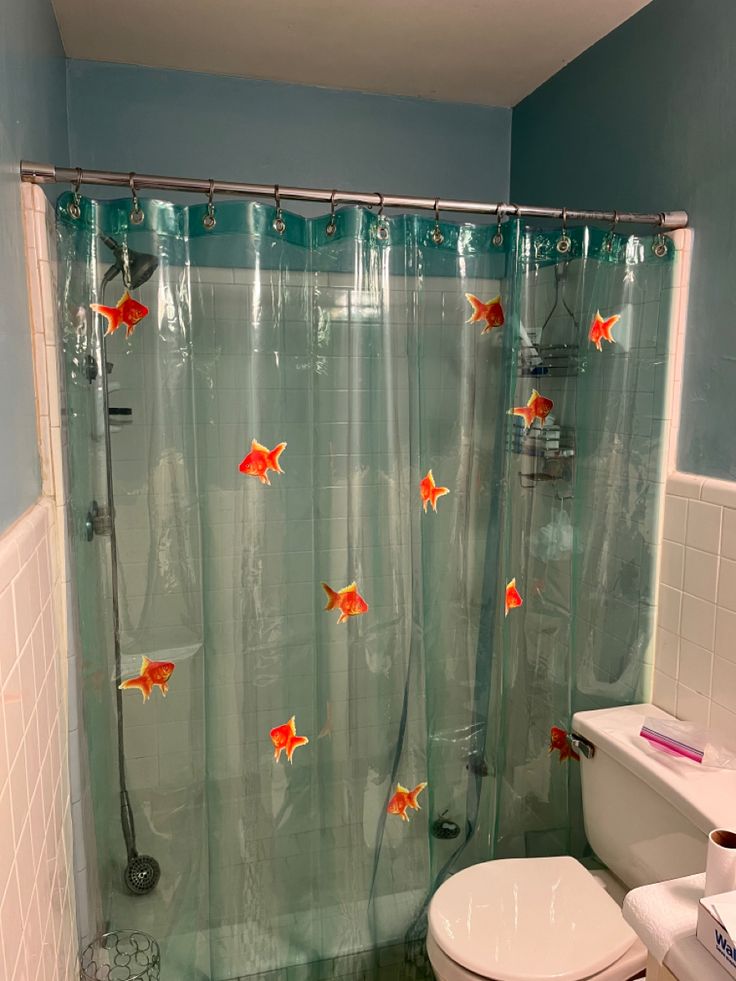 a white toilet sitting next to a bath tub in a bathroom under a shower curtain