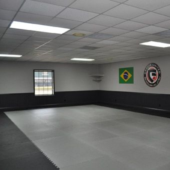 an empty room with two flags on the wall and windows in the center, all painted black