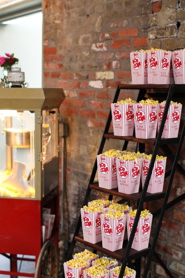 an old fashioned popcorn vending machine with red and white paper cups