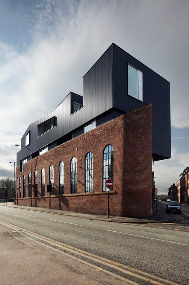 an old brick building with large windows on the side of it's face is shown