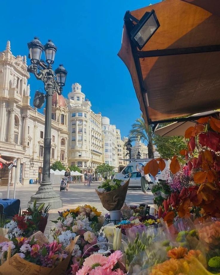 flowers are laid out on the sidewalk in front of a street light and lamp post