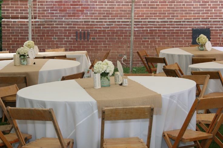 there are many tables and chairs set up for a wedding reception in front of a brick wall