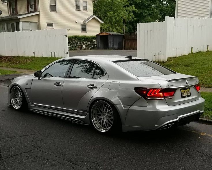 a silver car is parked on the side of the road in front of some houses