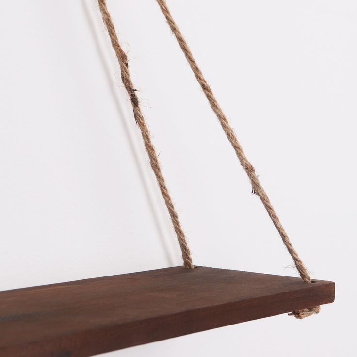 a wooden shelf with rope hanging from it