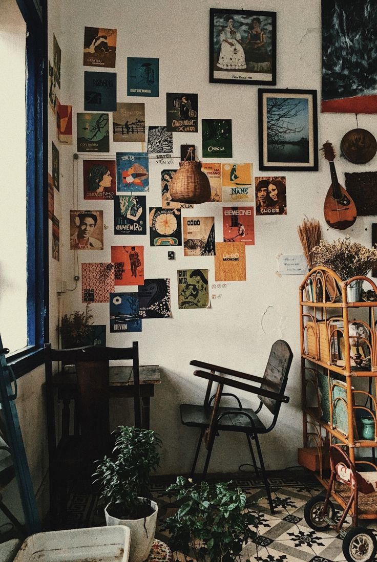 a room filled with lots of pictures on the wall next to a chair and potted plant