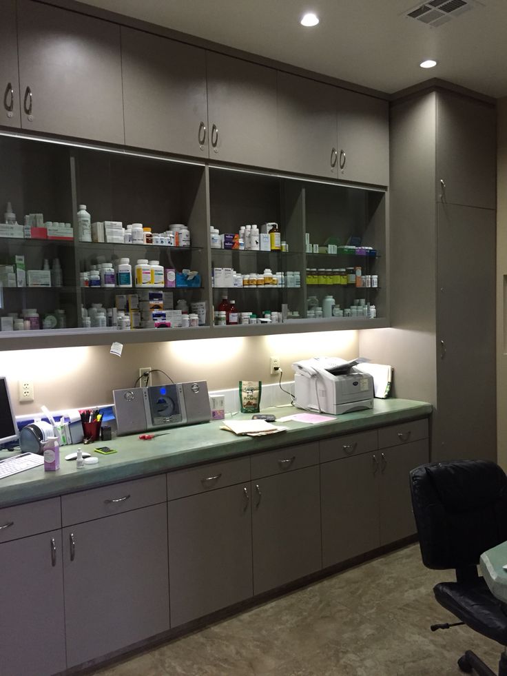 an office with lots of counter space and shelves filled with medicine bottles on the wall