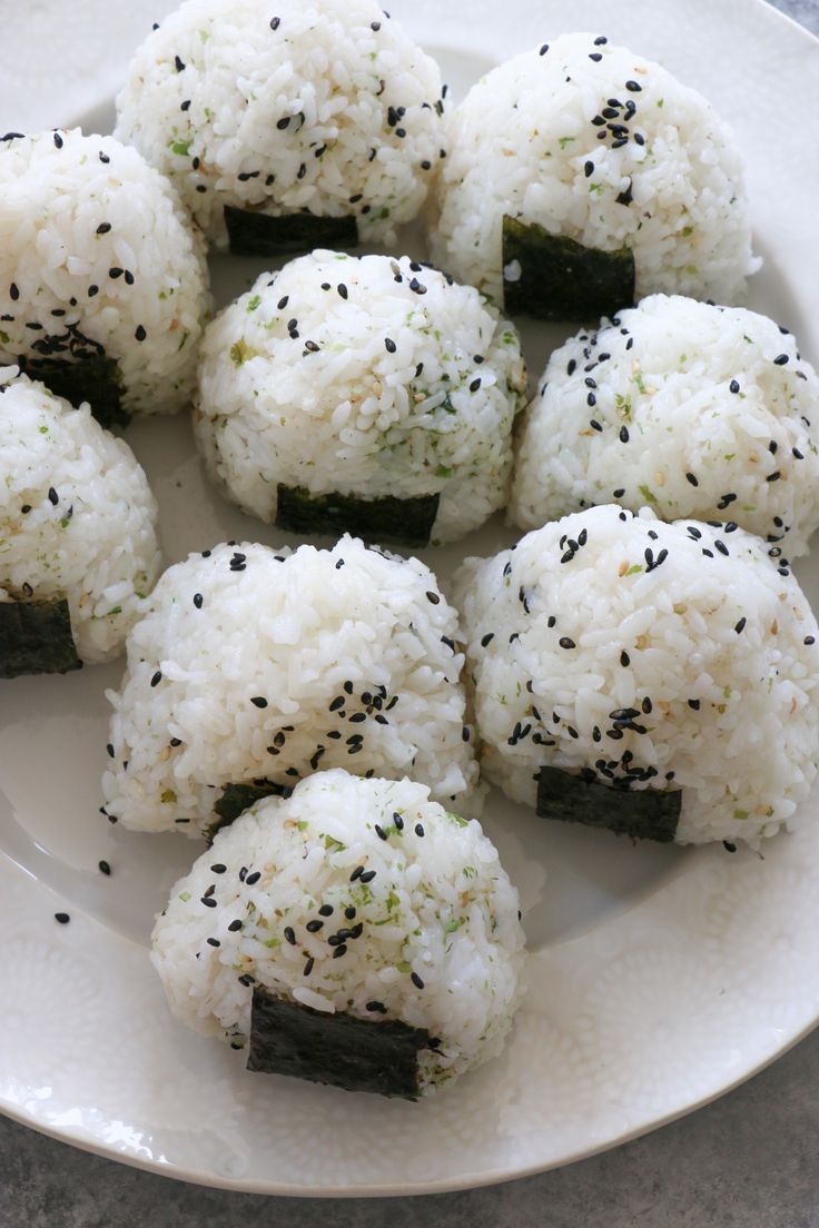 white rice balls with black sesame seeds on a plate