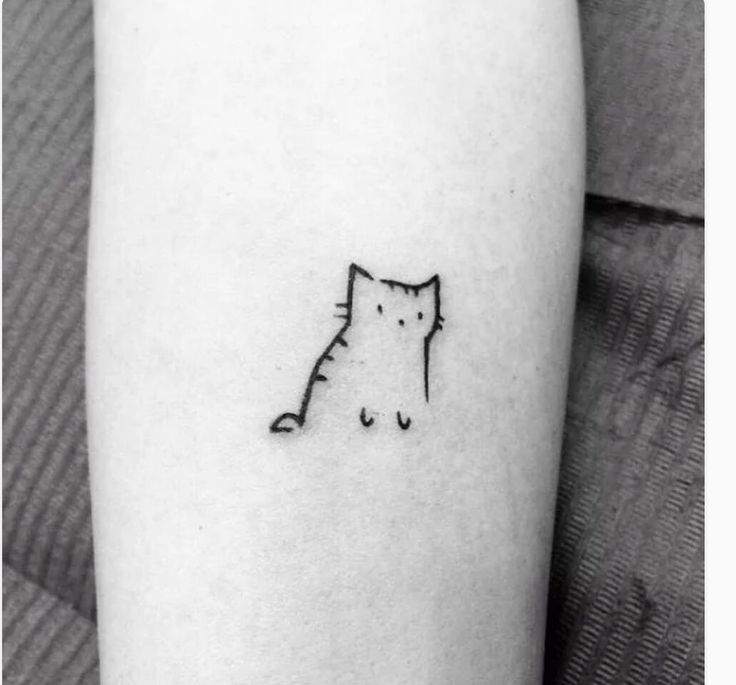 a black and white photo of a cat tattoo on the left arm, with an outline of a cat behind it