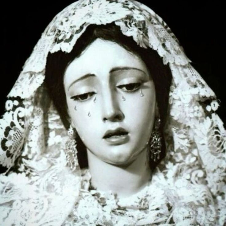 an old black and white photo of a woman wearing a veil with her eyes closed