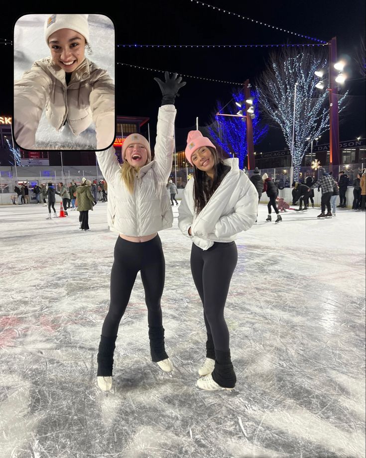 two women standing on an ice rink with their arms in the air and smiling at the camera