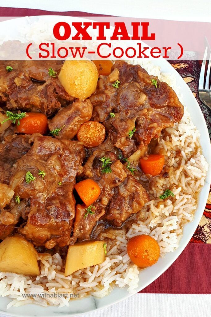 a white plate topped with rice and meat next to a fork, knife and fork